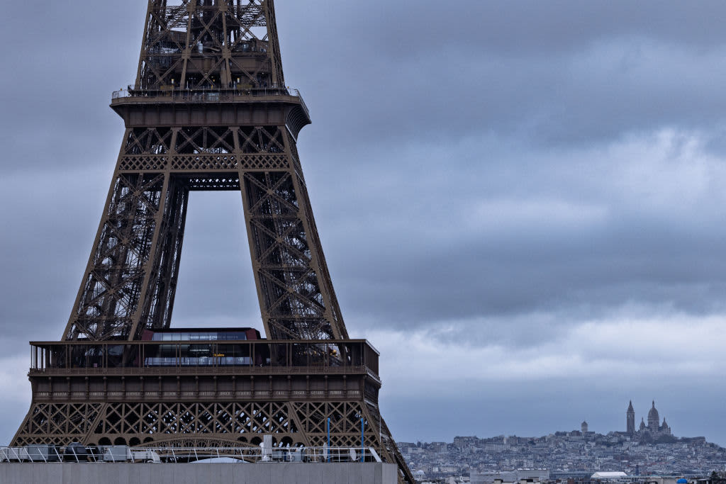 This photograph shows part of the Eiffel Tower with the Sacre-Coeur Basilica in the background, in Paris, on November 27, 2024.